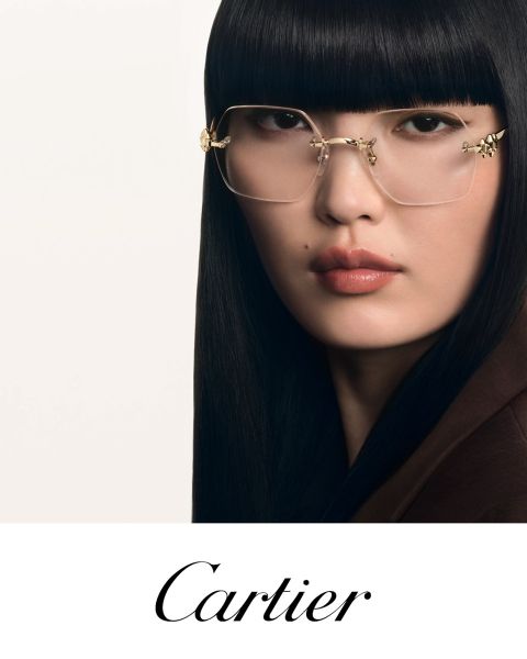 Mujer con cabello negro liso y gafas con montura dorada mirando a la cámara. Debajo, en elegante escritura, pone "Cartier".