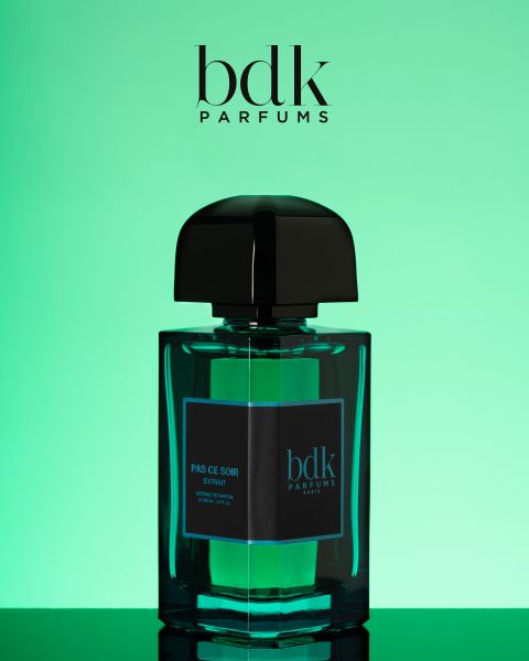 Un frasco de BDK Parfums "Pas Ce Soir"-Extrait con un elegante tapón negro se presenta sobre un fondo verde degradado. El logotipo de BDK Parfums se muestra en la parte superior de la imagen.