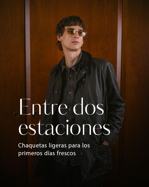 Un joven con gafas de sol y chaqueta oscura está de pie frente a una pared de madera. El texto dice: "Entre dos estaciones. Chaquetas ligeras para los primeros días frescos.".