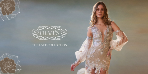 Una mujer con un vestido de encaje floral con mangas transparentes posa frente a un fondo suave y neutro. El texto a la izquierda dice "Olvis The Lace Collection" con ilustraciones florales decorativas.