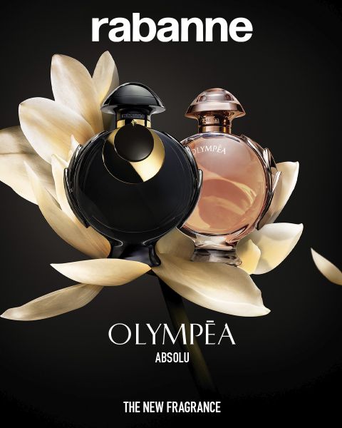 Dos frascos del perfume Rabanne Olympéa ABSOLU, uno negro y otro rosa, se exhiben frente a una flor blanca floreciente sobre un fondo oscuro. El texto dice: "Rabanne OLYMPÉA ABSOLU - LA NUEVA FRAGANCIA".