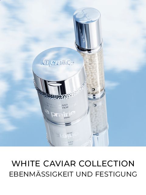 Dos productos para el cuidado de la piel de la colección White Caviar de La Prairie se presentan sobre un fondo de cielo azul nublado. El texto debajo dice: "Colección White Caviar: Luminosidad y Firmeza".