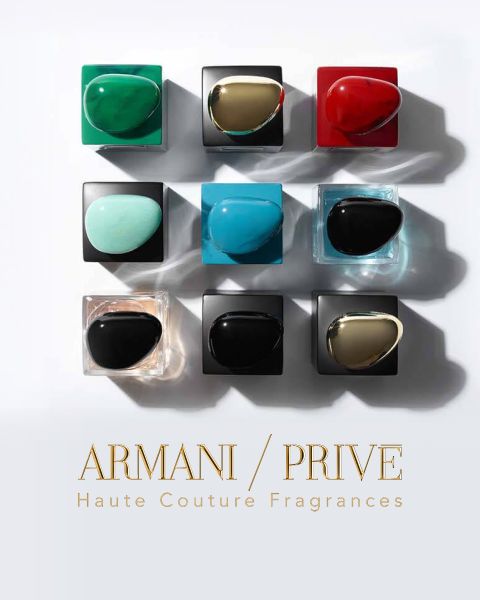 Una cuadrícula de nueve frascos de perfume Armani/Privé con tapas de diferentes colores, dispuestos en tres filas sobre un fondo claro. El texto debajo dice "Armani/Privé Fragancias de Alta Costura".