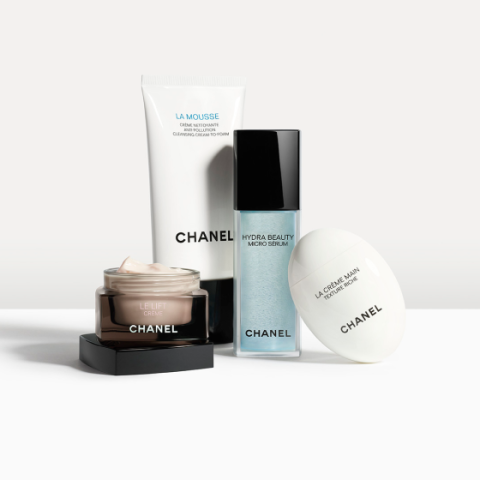 Cuatro productos para el cuidado de la piel de Chanel están dispuestos sobre un fondo claro: una espuma limpiadora, un micro serum, una crema hidratante y una crema de manos, cada uno en un envase individual con el logotipo de la marca visible.