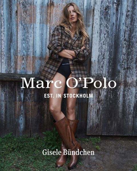 Una mujer con una camisa a cuadros, pantalones cortos negros y botas marrones está de pie frente a una pared de madera desgastada. El texto dice: "Marc O'Polo EST. EN ESTOCOLMO Gisele Bündchen.