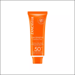 Eine leuchtend orangefarbene Tube Lancaster Sun Sensitive Luminous Tan SPF 50, die als ölfreies, milchiges Fluid, nicht fettend und wasserfest bezeichnet wird, mit weißer Kappe und weiß-goldener Schrift auf der Vorderseite.