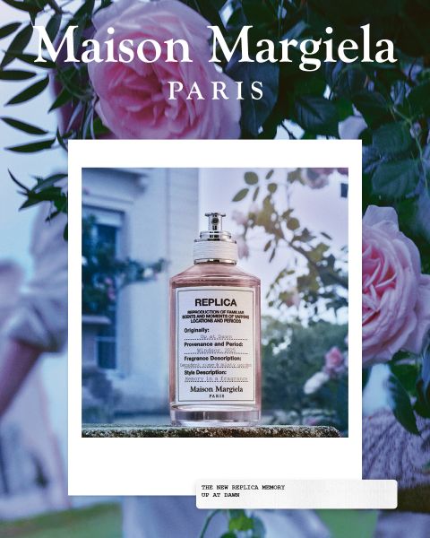 Un frasco del perfume "Replica Maison Margiela" con la inscripción "Under the Stars" se encuentra frente a un cielo estrellado con terreno rocoso. El texto en la parte inferior dice: "Las fragancias de las que están hechos tus recuerdos".