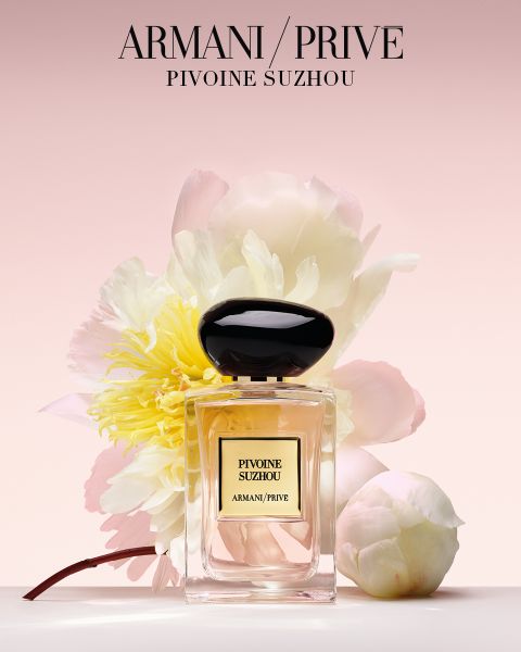 Una cuadrícula de nueve frascos de perfume Armani/Privé con tapas de diferentes colores, dispuestos en tres filas sobre un fondo claro. El texto debajo dice "Armani/Privé Fragancias de Alta Costura".