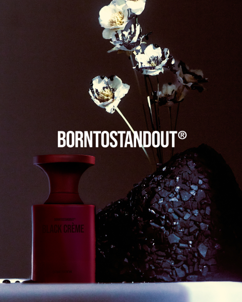 Una botella blanca con la inscripción "DIRTY MILK" se encuentra sobre una superficie reflectante con un cálido degradado rojo. Debajo, en negrita y en rojo, se lee "BORNTOSTANDOUT®".