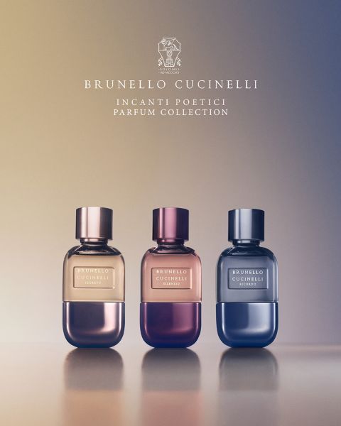 Seis frascos de perfume de Brunello Cucinelli están en fila sobre un lecho de flores coloridas y plantas verdes. El texto encima dice "Brunello Cucinelli" y debajo: "Incanti Poetici Parfum Collection".