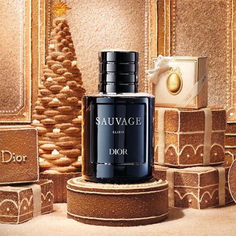 Un frasco de perfume "Dior Sauvage Extrait" con tapón negro, sobre un fondo blanco liso.