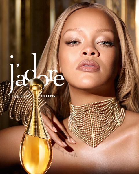 Una mujer con cabello rubio sostiene tres frascos de perfume Dior Addict en tonos naranja, rosa y lila, que incluyen el texto "DIOR ADDICT THE NEW PERFUMES".