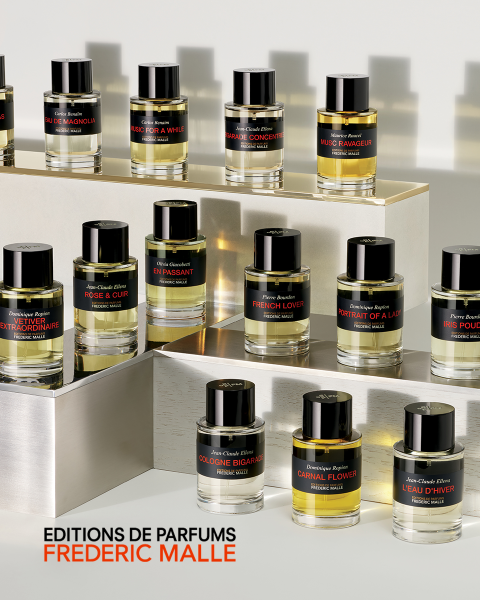 Primer plano de una persona en traje de baño blanco, con árboles borrosos al fondo. Un texto grande sobre la imagen dice "CARNAL FLOWER". En el texto adicional se menciona a Dominique Ropion y Editions de Parfums Frederic Malle.