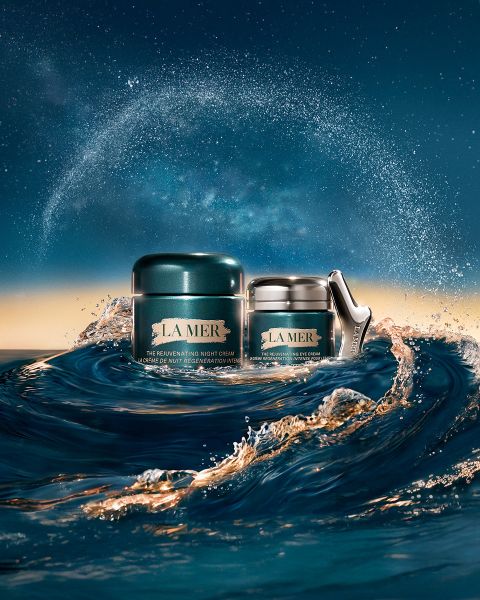 Un frasco de crema hidratante de La Mer flota sobre un agua azul brillante. El texto dice: "Regeneración del mar. Transformación visible. Día tras día." y "LA MER #LoveLaMer.