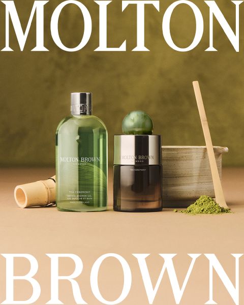 Disposición plana de varias botellas y recipientes de Molton Brown sobre un fondo claro, con el texto "Molton Brown London, Fragancia inconfundible, Hecho en Inglaterra" en el centro. Acentos esféricos de vidrio esparcidos por todas partes.