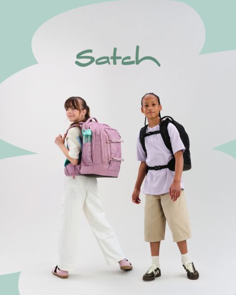 Cuatro niños con mochilas posan creativamente en un estudio. Uno está de pie en una escalera sosteniendo una claqueta, otro habla a través de un megáfono, dos más están arrodillados y sentados en cubos de colores. Se puede ver el equipo de estudio.