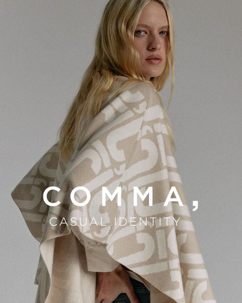 Una mujer con cabello largo y rubio lleva un poncho con estampado beige y blanco. Está de lado y mira por encima de su hombro. El texto en la imagen dice: "COMMA, CASUAL IDENTITY.