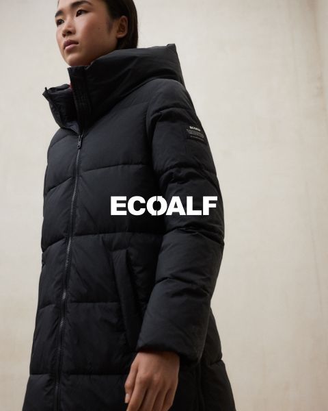 Una persona que lleva un abrigo de invierno acolchado negro está de pie frente a un fondo liso y claro. La palabra "ECOALF" se lee claramente en el centro de la imagen.