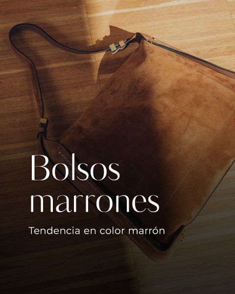 Un bolso marrón de gamuza con una correa de cuero sobre un piso de madera. El texto sobre la imagen dice: "Bolsos marrones. Tendencia en color marrón."