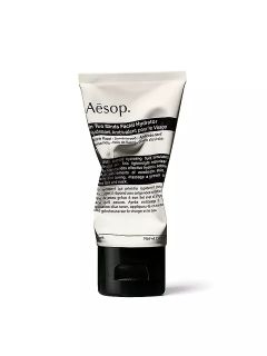 Un tubo de Aesop In Two Minds Facial Hydrator con una etiqueta blanca con texto negro y un cierre superior abatible negro, de pie verticalmente frente a un fondo blanco.