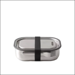 Eine rechteckige Brotdose aus rostfreiem Stahl mit einem transparenten Deckel, der durch ein schwarzes Gummiband gesichert ist, und einer unterhalb des Bandes angebrachten Gabel, die vor einem schlichten weißen Hintergrund steht.