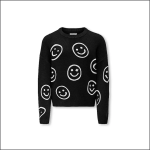 Ein schwarzer, langärmeliger Pullover mit einem Muster aus großen, weißen Smiley-Motiven, die über die Vorderseite, die Ärmel und die Schultern verstreut sind, auf einem schlichten weißen Hintergrund.