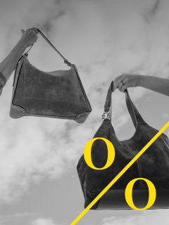 Dos manos sosteniendo cada una un bolso grande de gamuza contra un cielo nublado. La imagen está en blanco y negro con una línea diagonal amarilla y las letras "o" y "O" en amarillo.