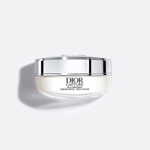 Un tarro blanco plateado de Dior Capture Rich Cream aparece representado sobre un sencillo fondo gris claro.