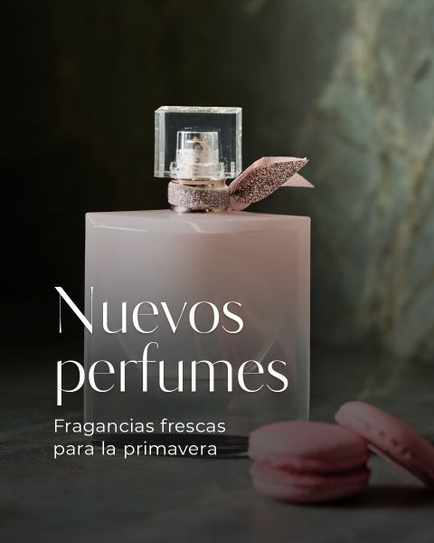 Un frasco de perfume rosa pálido con un lazo está al lado de macarons rosas; el texto en español dice "Nuevos perfumes. Fragancias frescas para la primavera.