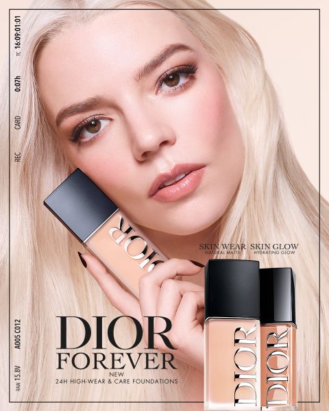 Una mujer con cabello rubio platino sostiene dos frascos de la base Dior Forever cerca de su rostro y promociona el producto con un maquillaje impecable.