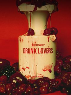 Un frasco de perfume con la inscripción "DRUNK LOVERS" está salpicado de líquido rojo y rodeado de cerezas y bayas sobre un fondo rojo intenso.