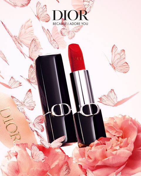 Un lápiz labial rojo de Dior en un estuche negro y plateado, rodeado de mariposas rosas, flores y un lazo con el logo de Dior.