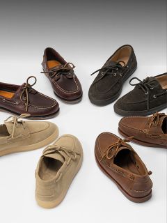 Siete pares de zapatos náuticos en varios colores, incluyendo marrón, marrón claro y negro, dispuestos en un círculo sobre un fondo blanco.