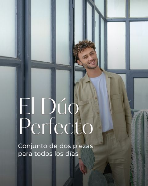 Un hombre con ropa de color beige claro está de pie sonriendo frente a unos ventanales. El texto en español dice: "El Dúo Perfecto. Conjunto de dos piezas para todos los días.".