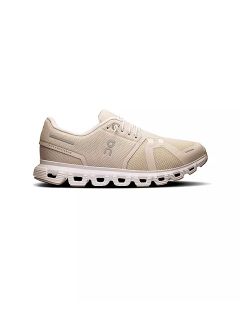Zapatilla deportiva beige con parte superior de malla, suela llamativa con forma de nube, cierre de cordones y marca mínima, representada en el perfil lateral sobre un fondo blanco.