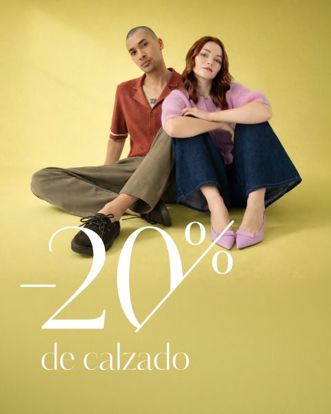 Dos modelos sentadas en un suelo amarillo con el texto "-20% de calzado". Se ven relajadas y con estilo, mostrando sus zapatos.