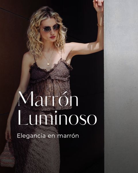 Una mujer con un vestido de encaje marrón y gafas de sol está de pie junto a una pared. El texto dice: "Marrón Luminoso. Elegancia en marrón.".