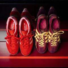 Dos pares de zapatillas Adidas: un par rojo con rayas blancas y un par morado y amarillo, ambos sobre un fondo a rayas rojas, vistos desde arriba.