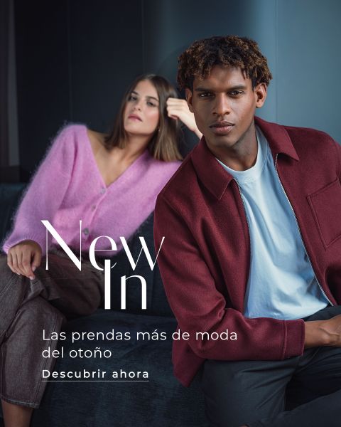 Una mujer con un cárdigan rosa y un hombre con una chaqueta burdeos están sentados en un sofá oscuro. El texto dice: «Recién llegados. Las prendas de otoño más de moda. Descúbrelas ahora.»