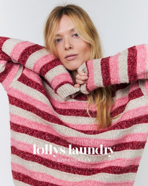 Una mujer con un jersey de rayas rosa y rojo posa con los brazos levantados sobre un fondo blanco. Debajo está el texto "Lollys Laundry Copenhagen".