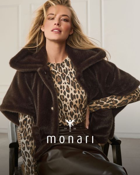 Una mujer con una capa de piel sintética sobre un top con estampado de leopardo y una falda marrón está sentada y posando; abajo se ven "monari" y el logo.