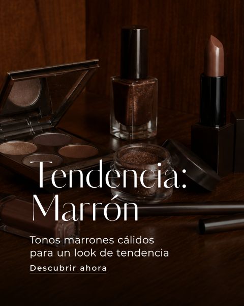 Productos de maquillaje marrones, incluyendo sombra de ojos, lápiz labial, esmalte de uñas y brochas, dispuestos sobre una superficie de madera oscura con texto elegante en español.