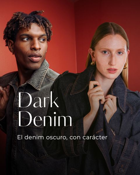Un hombre y una mujer llevan chaquetas vaqueras oscuras y están de pie delante de una pared roja. El texto dice: "Dark Denim. El denim oscuro, con carácter.".