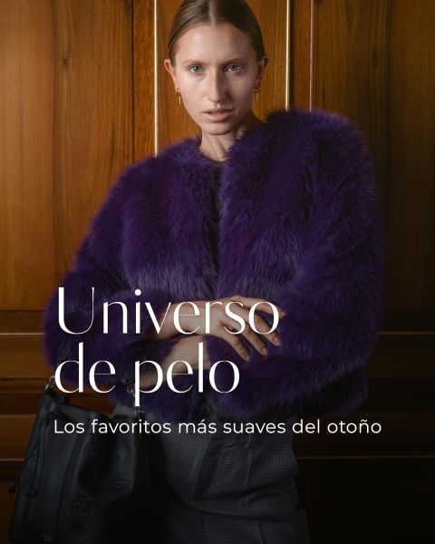 Una mujer con un abrigo de piel morado está de pie con los brazos cruzados. El texto en español dice: "Universo de pelo. Los favoritos más suaves del otoño.".