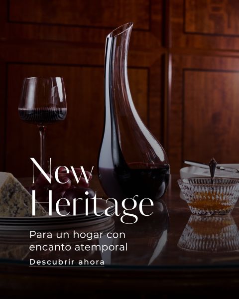 Sobre una mesa hay una jarra de vino, una copa de vino tinto, queso y miel, junto con un texto en español que elogia el encanto atemporal del hogar.