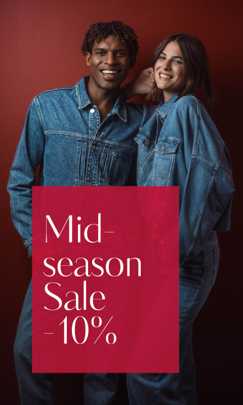 Dos personas con atuendos de mezclilla posan sonriendo frente a una pared roja. La imagen dice: "Venta de mitad de temporada - 10 %".