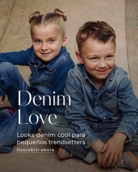 Una niña y un niño, vestidos con camisas y pantalones vaqueros, sentados en un suelo de madera bajo el letrero "Denim Love".