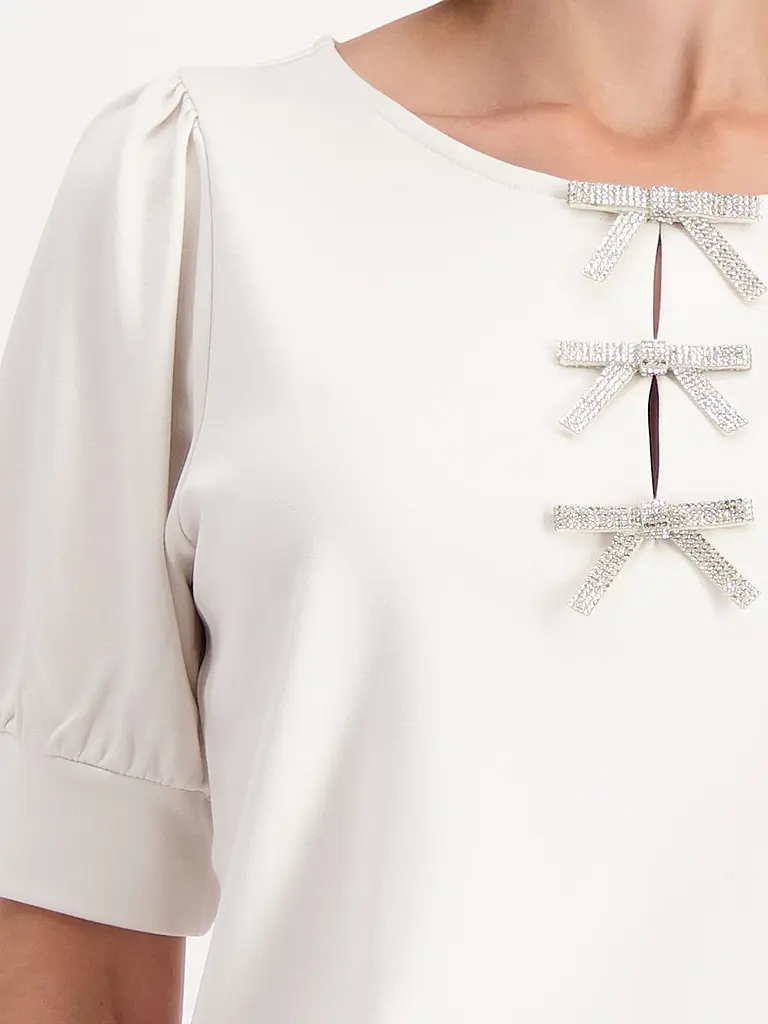 MONARI | Nombre del producto: Camiseta
Marca: MONARI
Color: beige
Categorías: Moda, Mujer
Largo de manga: Manga corta
Escote: Cuello redondo
Material: Jersey, Viscosa, Elástico
Estampado: Liso
Corte (Prenda superior): Regular
Estilo: Glamour
Detalles: Estrás |